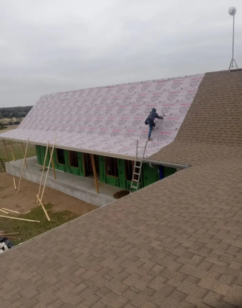 Worker preparing underlayment for a metal roof installation in Fitzgerald